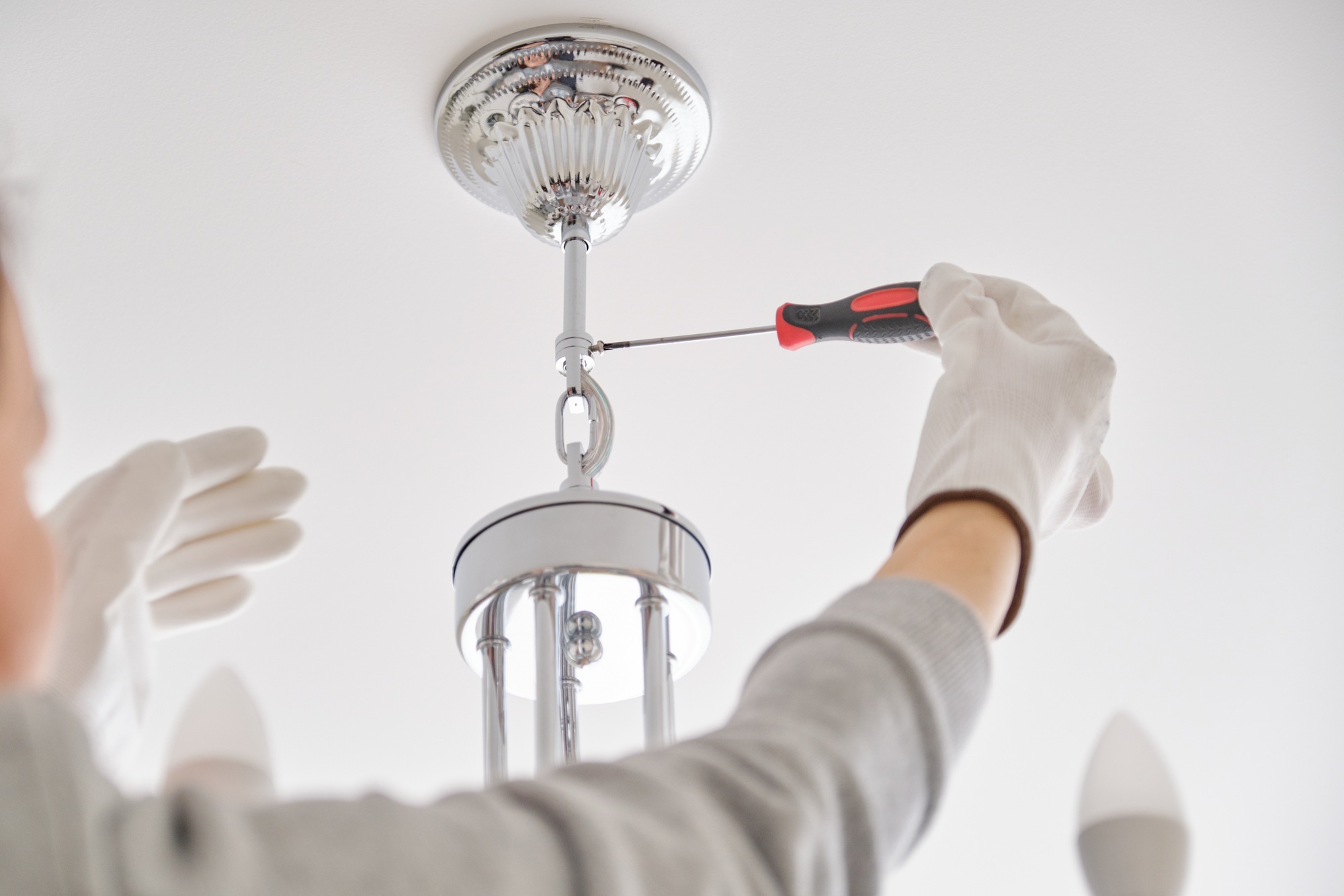 Installation ceiling lamp, hands of electrician fixing chandelier